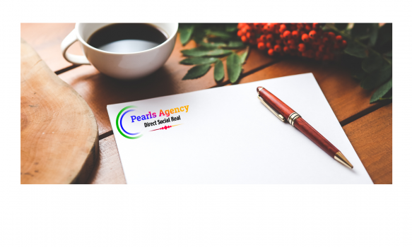 A cup of tee with a pen on a branded note book on a table with flowers beside them